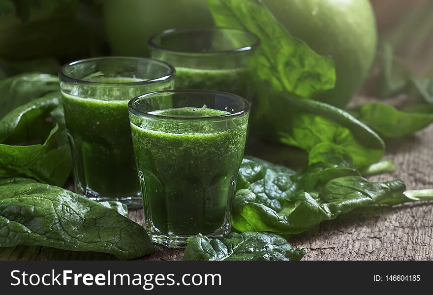 Green spinach detox smoothies with apples and lemon in glasses, selective  focus