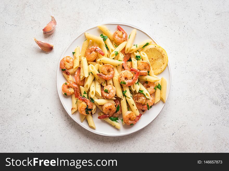 Penne Pasta with Prawns or Shrimps, lemon and garlic on white, top view, copy space. Lemon pasta with sauteed shrimps, fresh seafood. Penne Pasta with Prawns or Shrimps, lemon and garlic on white, top view, copy space. Lemon pasta with sauteed shrimps, fresh seafood