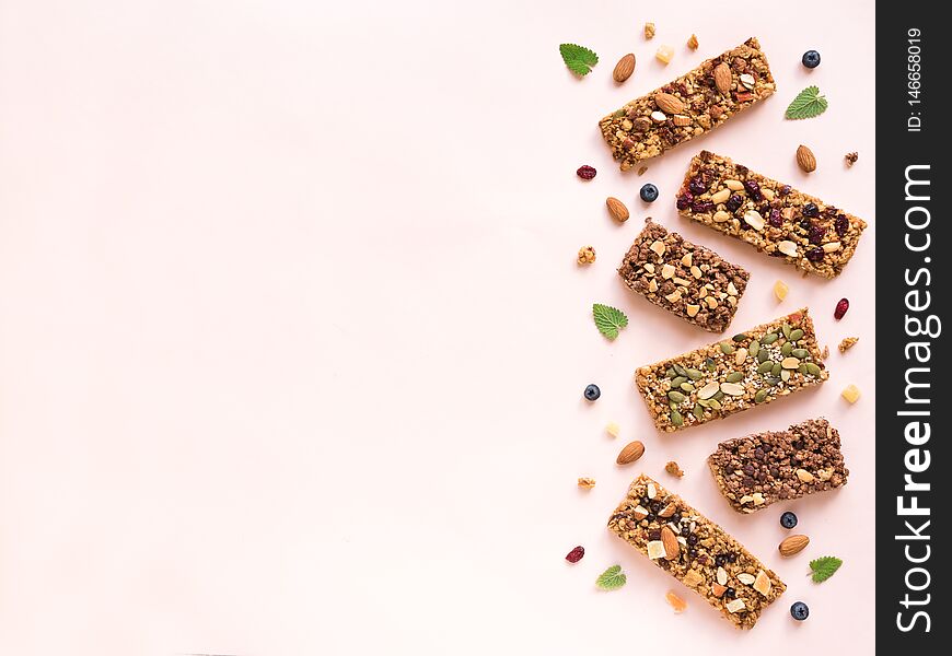 Granola bars assortment on white pink background, copy space. Homemade healthy snack - granola superfood bars