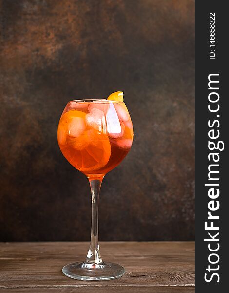 Aperol Spritz Cocktail in glasses on wooden table, copy space. Homemade cocktail with orange and ice