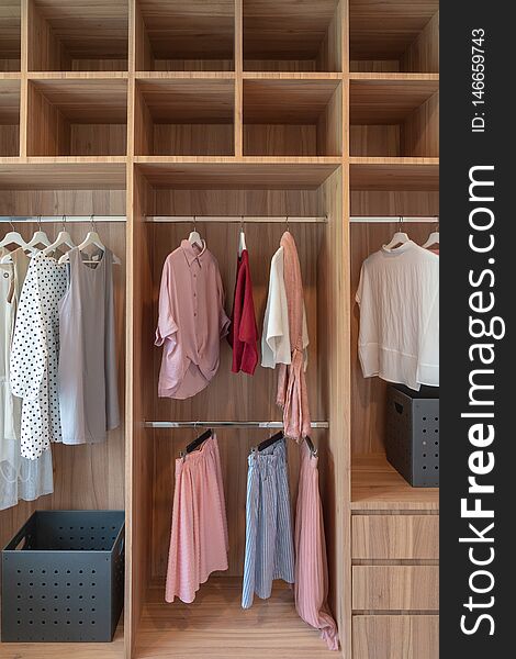 modern closet with clothes hanging on rail, white wooden wardrobe, interior design concept