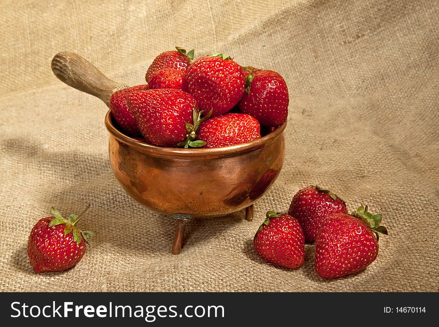 Fresh organic strawberry in a copper bowl