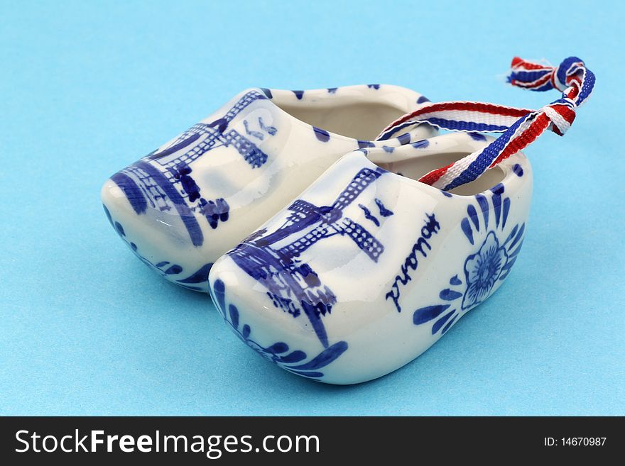Delft blue ceramic wooden shoes from Holland on a blue background