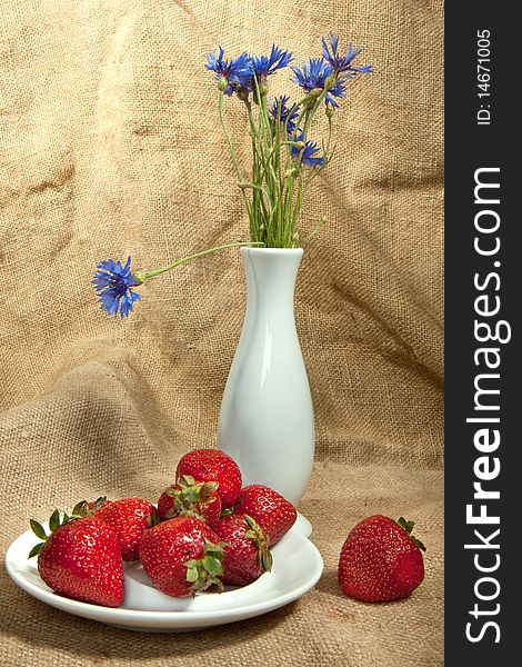 Fresh strawberry and vase with flowers