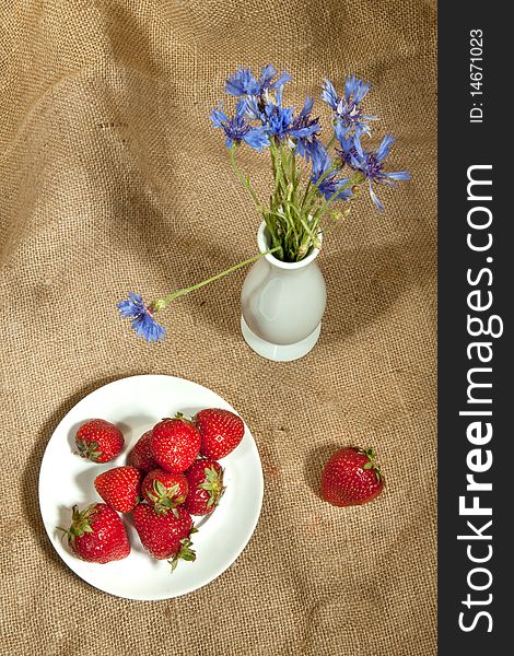 Fresh strawberry and vase with flowers