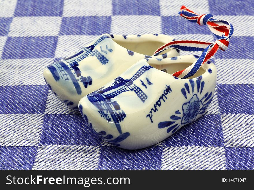 Delft blue ceramic wooden shoes from Holland on a blue checkered kitchen towel