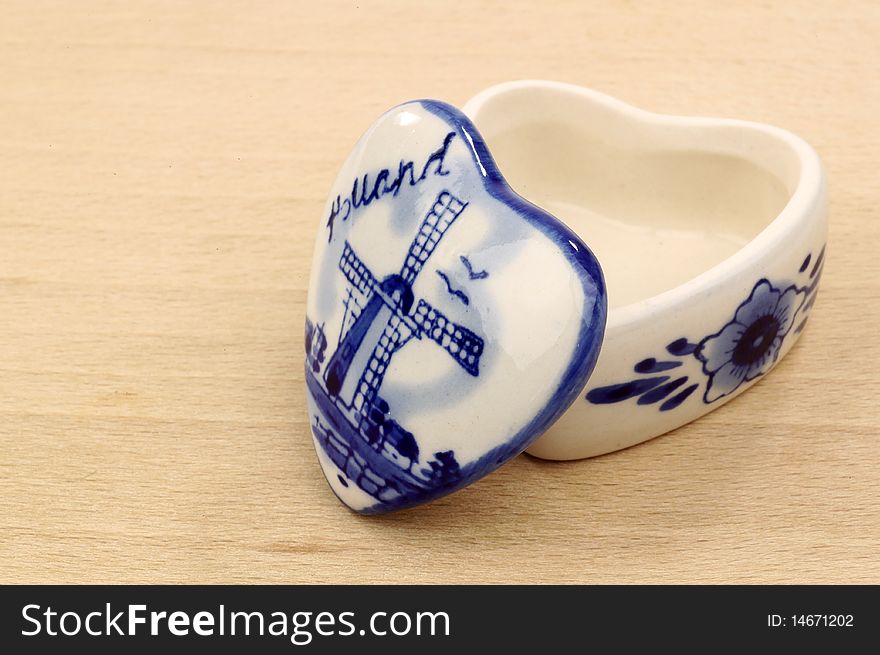 Opened ceramic pill box on a wooden background