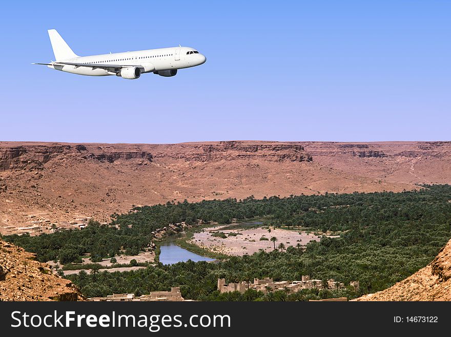 An airbus plane is flying over a saharan oasis. An airbus plane is flying over a saharan oasis.