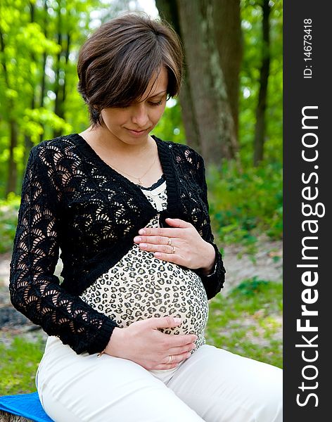 Pregnant woman in park. Outdoor shot. Pregnant woman in park. Outdoor shot