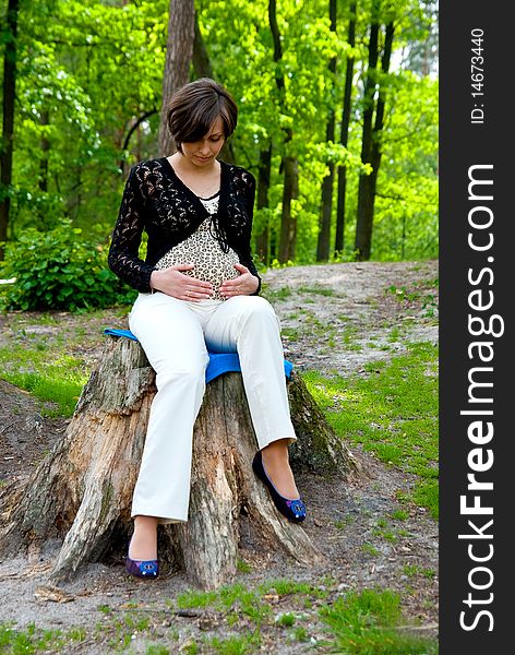 Beautiful pregnant woman in the wood. Outdoor shot