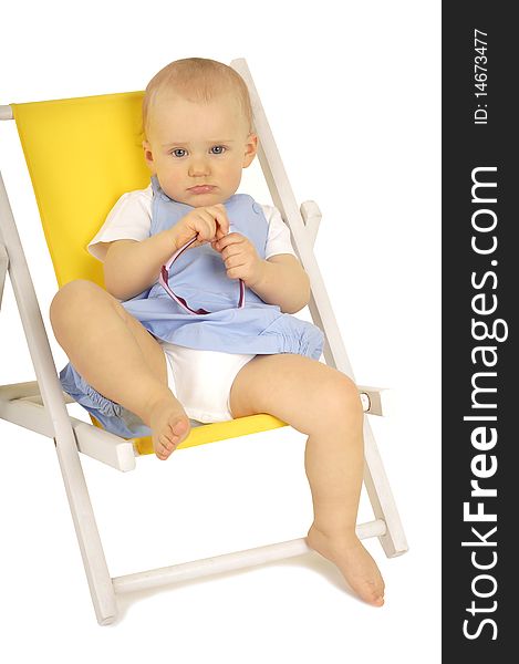 Baby with sunglasses sitting on yellow deckchair. Baby with sunglasses sitting on yellow deckchair