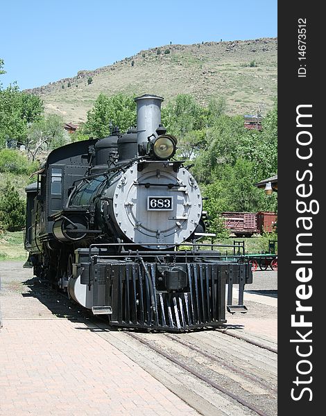 An impressive antique locomotive sits at the train depot. An impressive antique locomotive sits at the train depot.