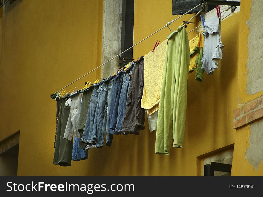 Laundry hanging on a clothes line on a bright yellow building in Venice, Italy. Laundry hanging on a clothes line on a bright yellow building in Venice, Italy.