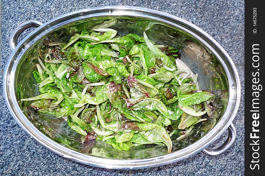 Lettuce salad with  dressing in a pot on stone background