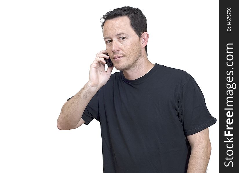 A young man speaking to a friend with his phone. A young man speaking to a friend with his phone