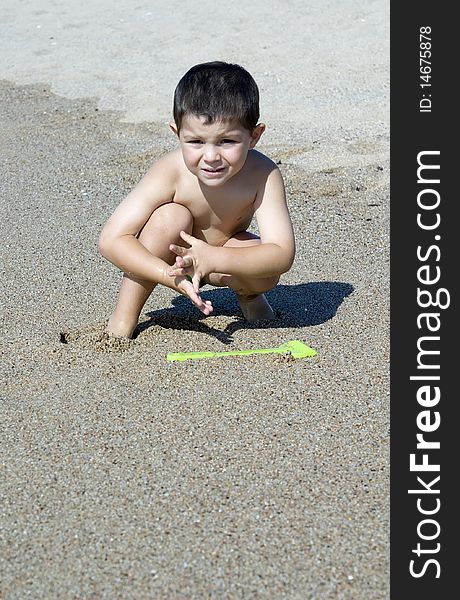 A kid playing on the beach sand. A kid playing on the beach sand