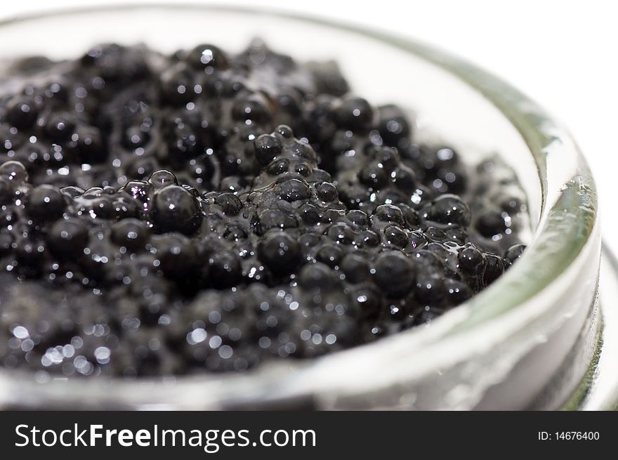 Black caviar in a glass jar on a white background