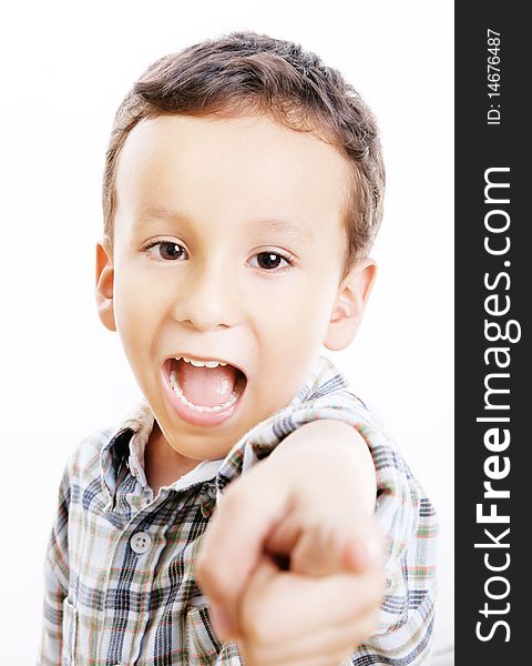 Child pointing and looking at the camera. White background. Child pointing and looking at the camera. White background