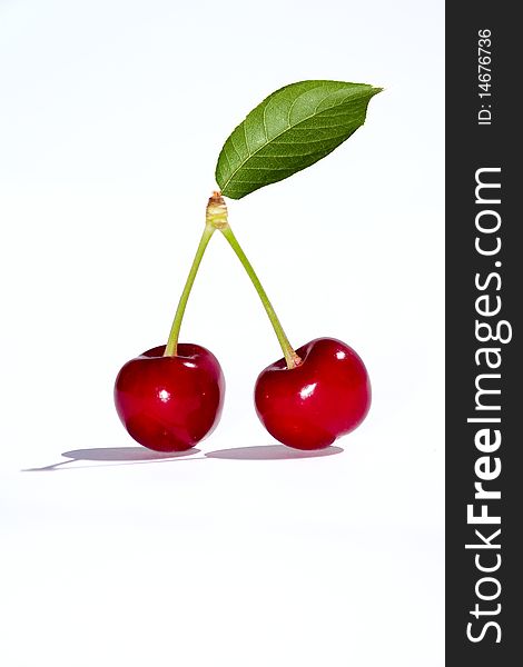 Two cherries on white background with leaf. Two cherries on white background with leaf