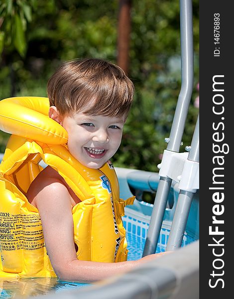 Happy boy smiles in swimming pool with life jacket. Happy boy smiles in swimming pool with life jacket