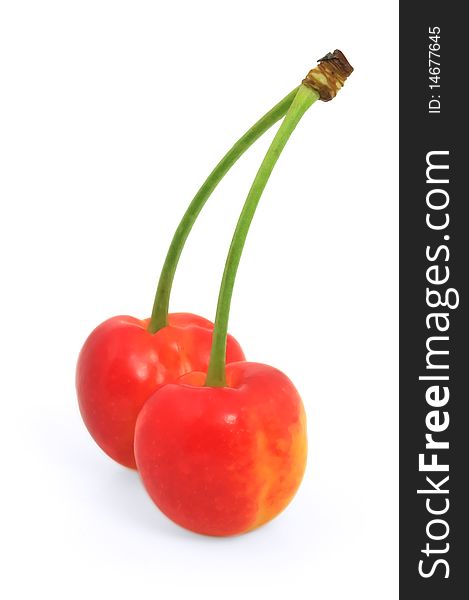 Two cherries against white background