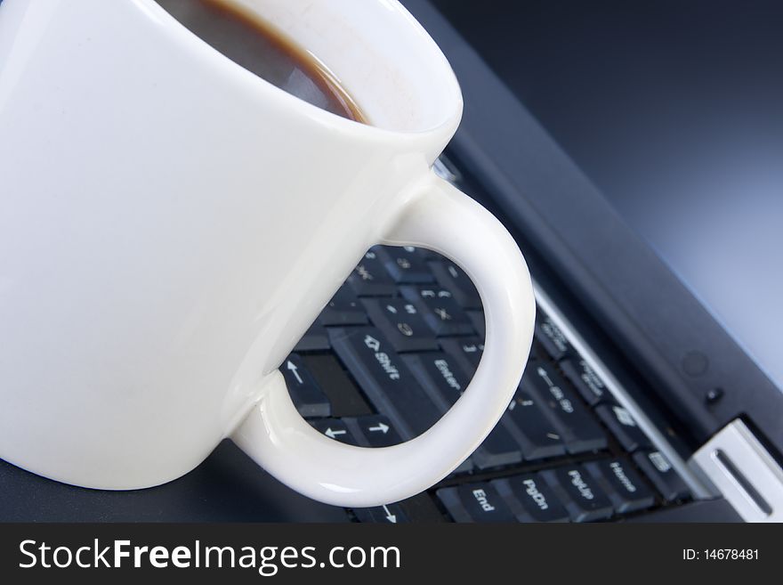 Cup on a laptop keyboard. Cup on a laptop keyboard