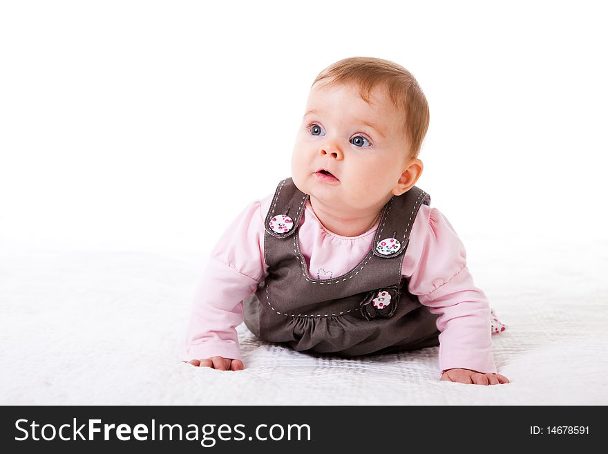 A baby girl is crawling along the floor with an inquisitive look on her face. Horizontal shot. A baby girl is crawling along the floor with an inquisitive look on her face. Horizontal shot.