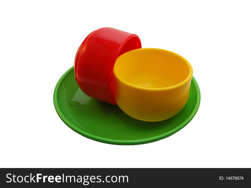 Red and yellow mugs on a green plate. Red and yellow mugs on a green plate