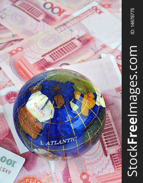 A color globe and lot of money bills, means money, rich, fortune, world wide economy, development and business concept. A color globe and lot of money bills, means money, rich, fortune, world wide economy, development and business concept.