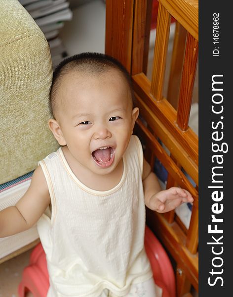 A Chinese baby is in home. He is very happy. A Chinese baby is in home. He is very happy.
