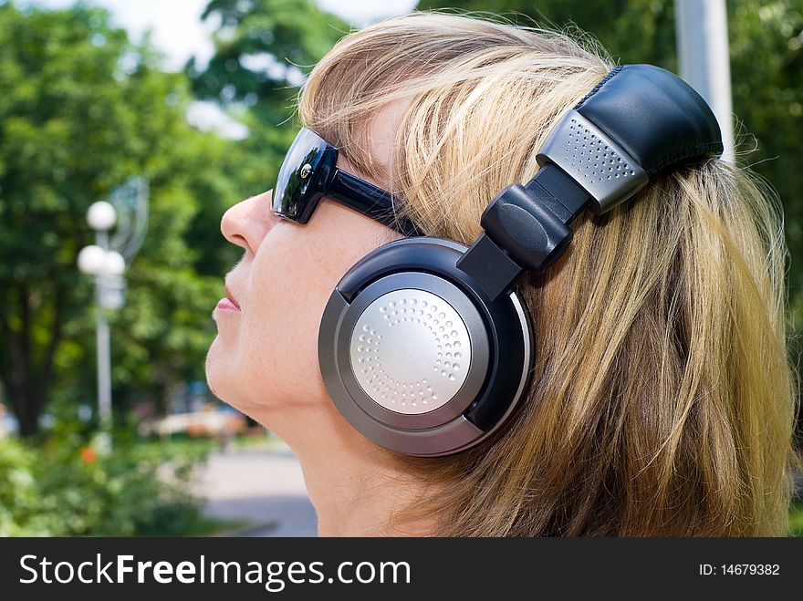 Young woman listening music in park