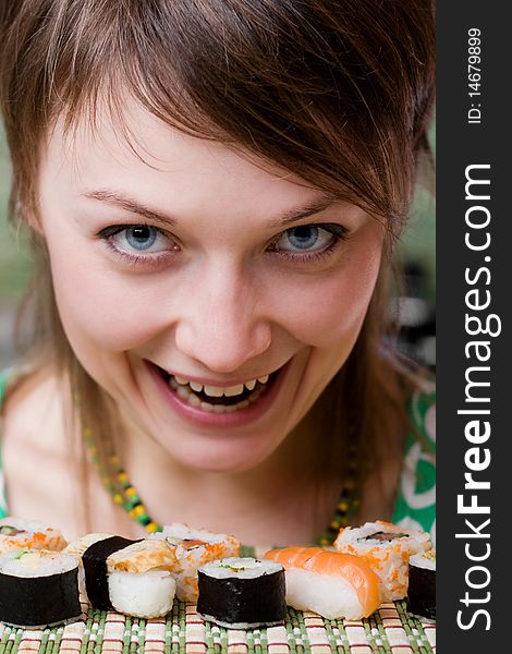 An image of a young woman eating sushi