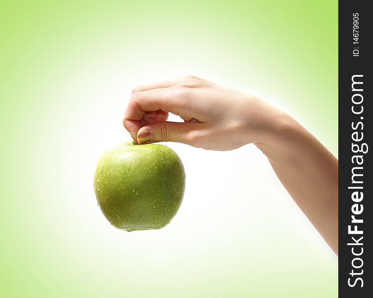 Image of a fresh and tasty apple held in a human hand. Isolated on a ligh green gradient background. Image of a fresh and tasty apple held in a human hand. Isolated on a ligh green gradient background.