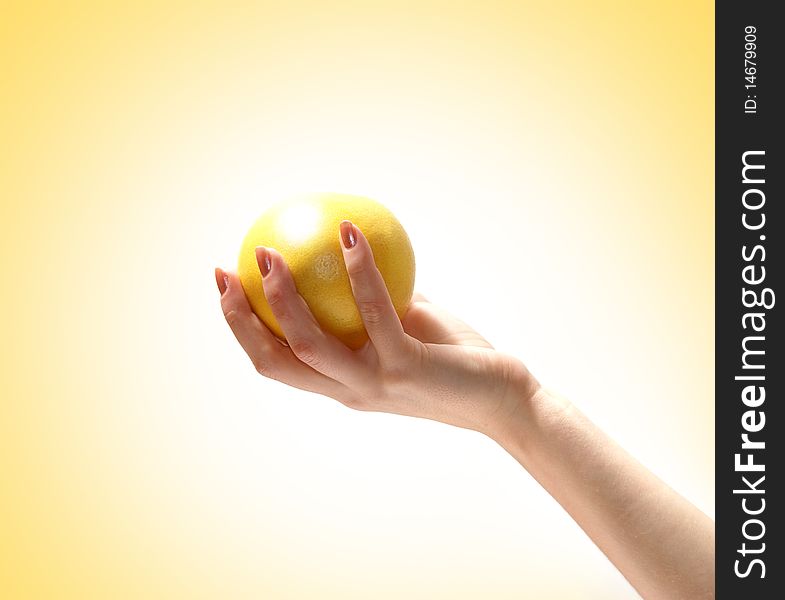 Image of a fresh and tasty lemon held in a human hand. Isolated on a ligh yellow gradient background. Image of a fresh and tasty lemon held in a human hand. Isolated on a ligh yellow gradient background.