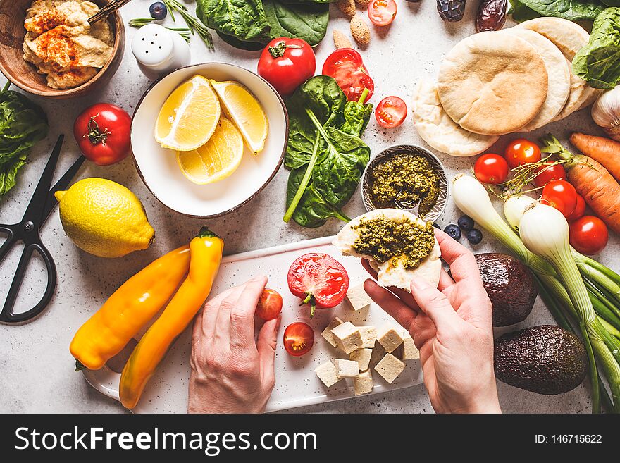 Cooking healthy vegetarian food background. Vegetables, hummus, pesto and fruits, top view. Cooking healthy vegetarian food background. Vegetables, hummus, pesto and fruits, top view
