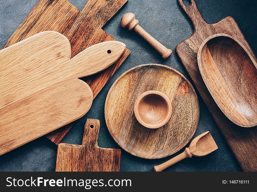 Set of wooden kitchen utensils, cutting boards, bowl, plate, mortar and pestle, scoop. Flat lay, top view