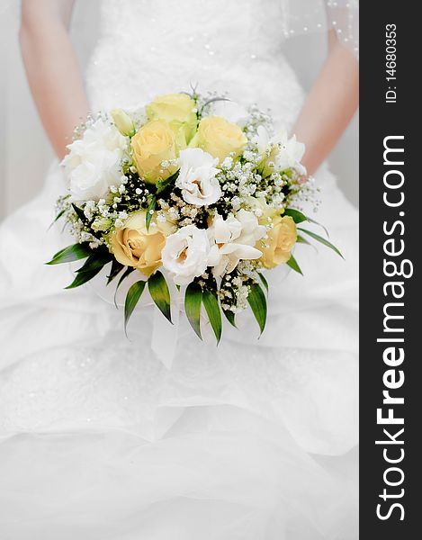 Bride holding a beautiful white and yellow wedding bouquet