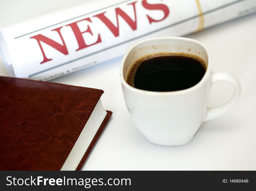 An image of a cup of coffee and newspaper. An image of a cup of coffee and newspaper