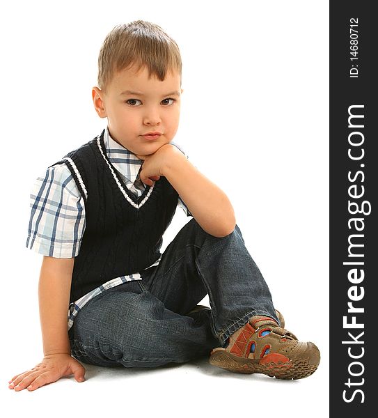 Little boy sitting on floor against white background