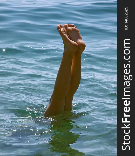 Young women feet in the blue Adriatic sea