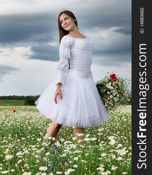 Young happy girl with bouquet in daisy field. Young happy girl with bouquet in daisy field