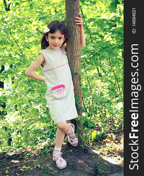 Little Girl Standing Near A Tree