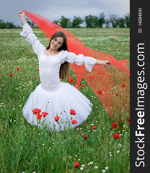 Young happy girl with red veil in field. Young happy girl with red veil in field