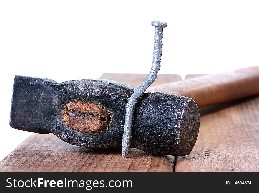 The bent nail sits on a hammer, a metalwork workshop.