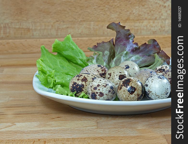 Boiled quail eggs garnished with lettuce on plate