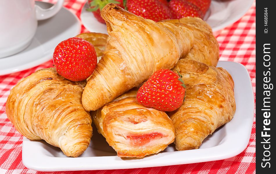 Fresh croissants and strawberry with cup of coffee