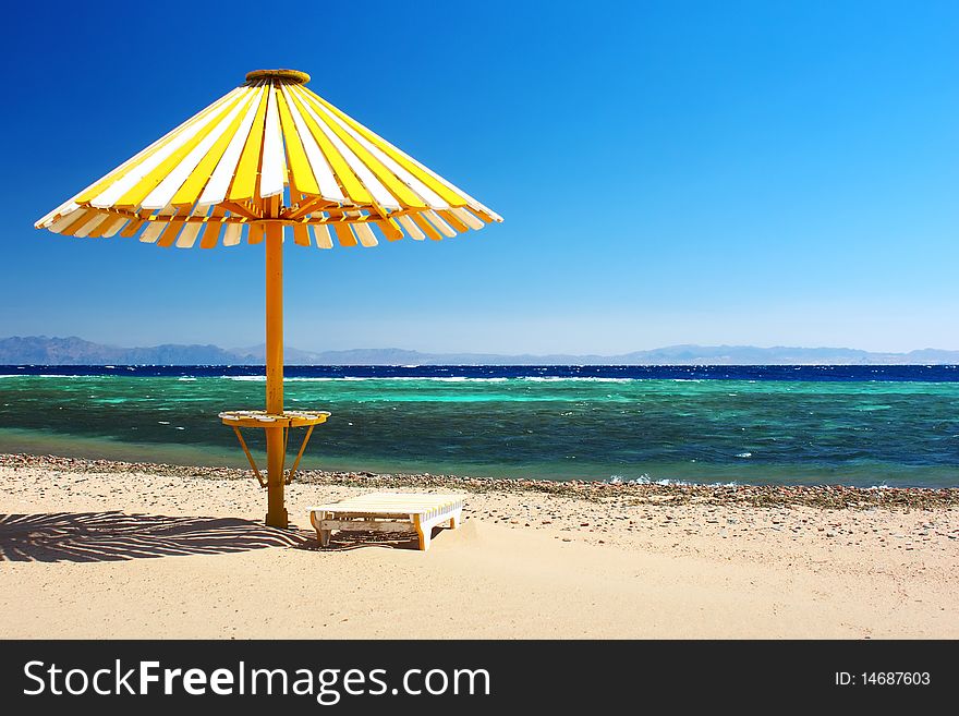 Wood umbrella on beach with clear blue sky
