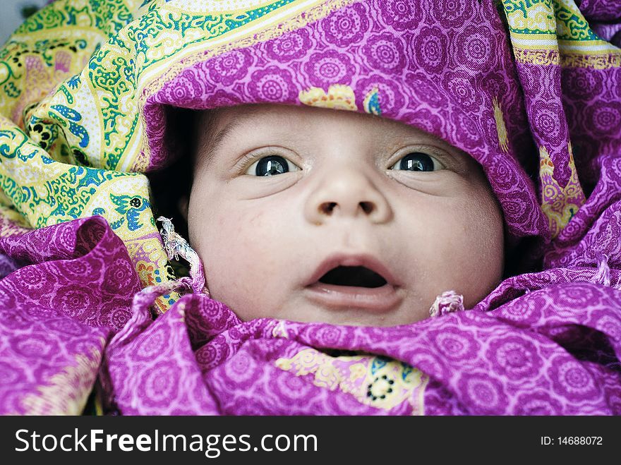 The surprised and happy baby in red cloak