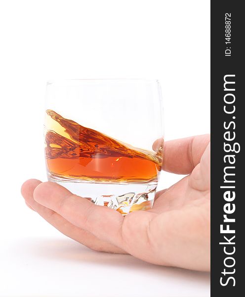 Glass of brandy holding by hand