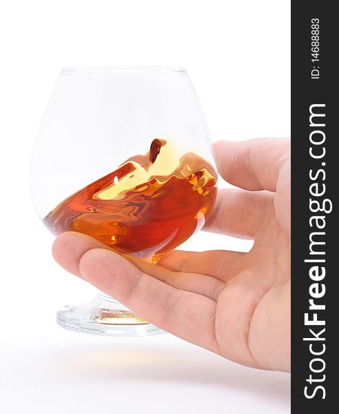 Glass of brandy holding by hand isolated on white